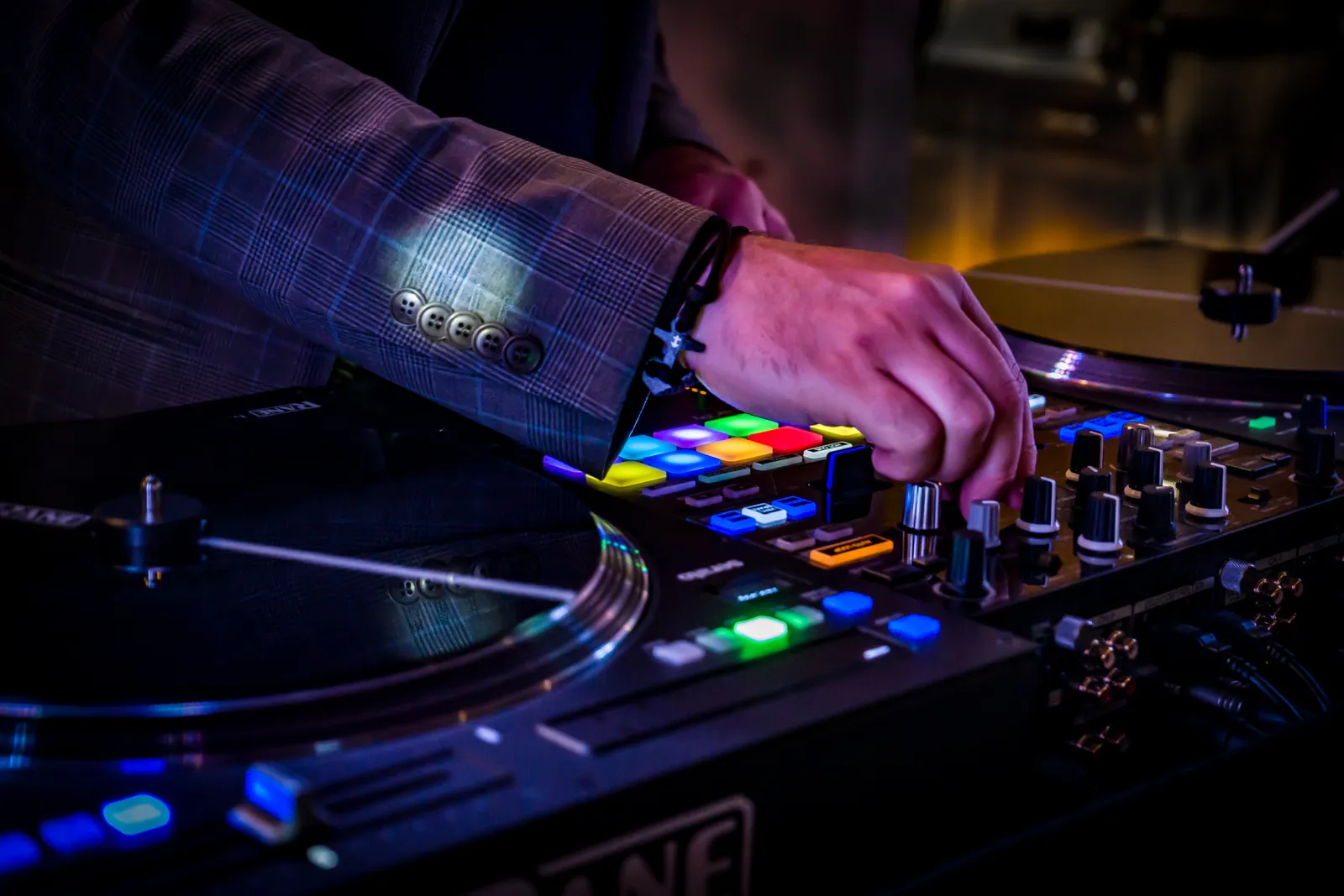 Hände im Sakko am DJ-Controller
